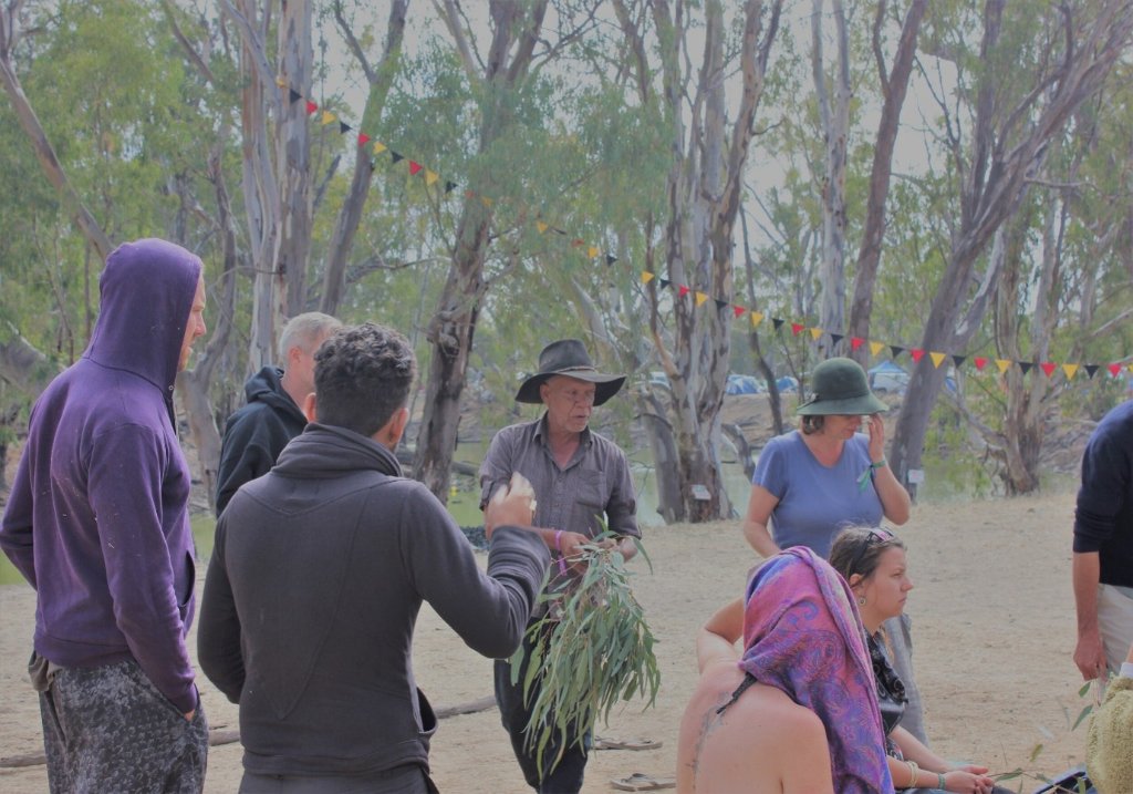 Community gathering with smoke ceremony in the bush