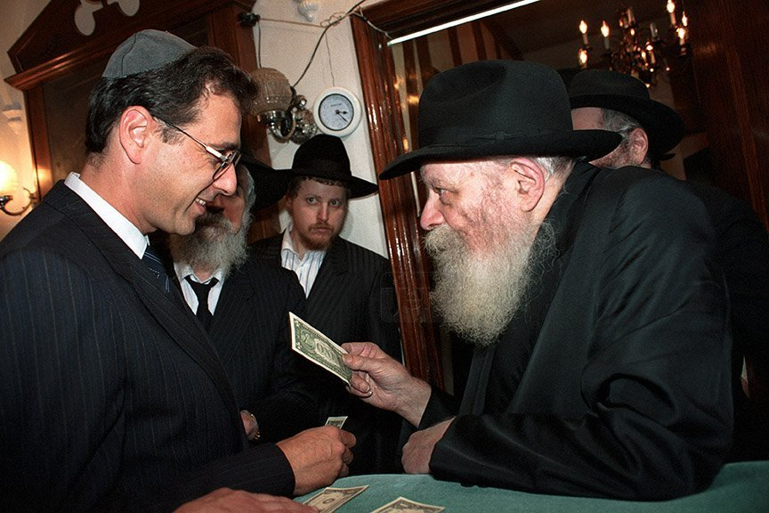 The Rebbe giving tzedakah