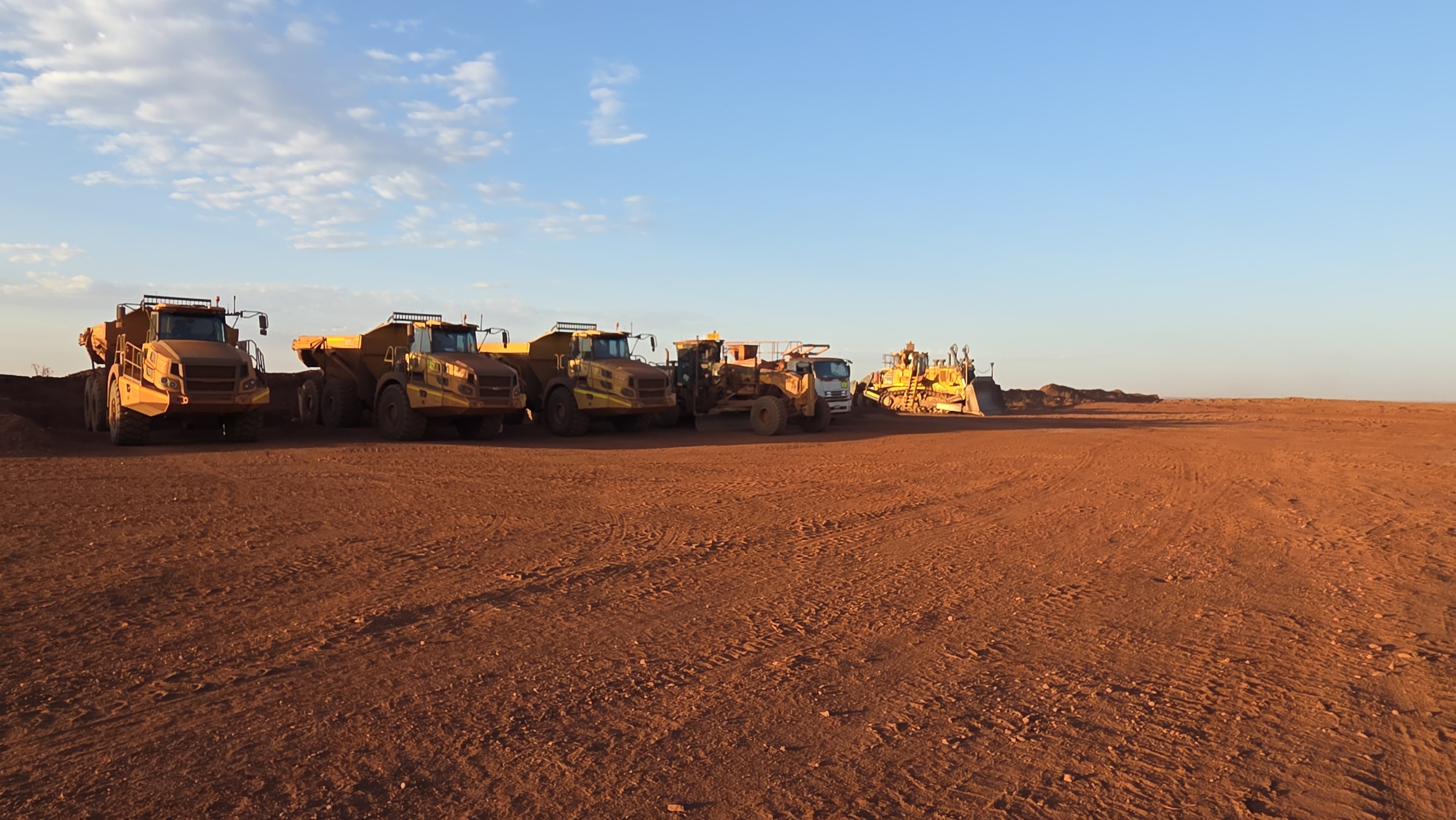 Bell B45E dump trucks, motor grader and bulldozer lined up on site