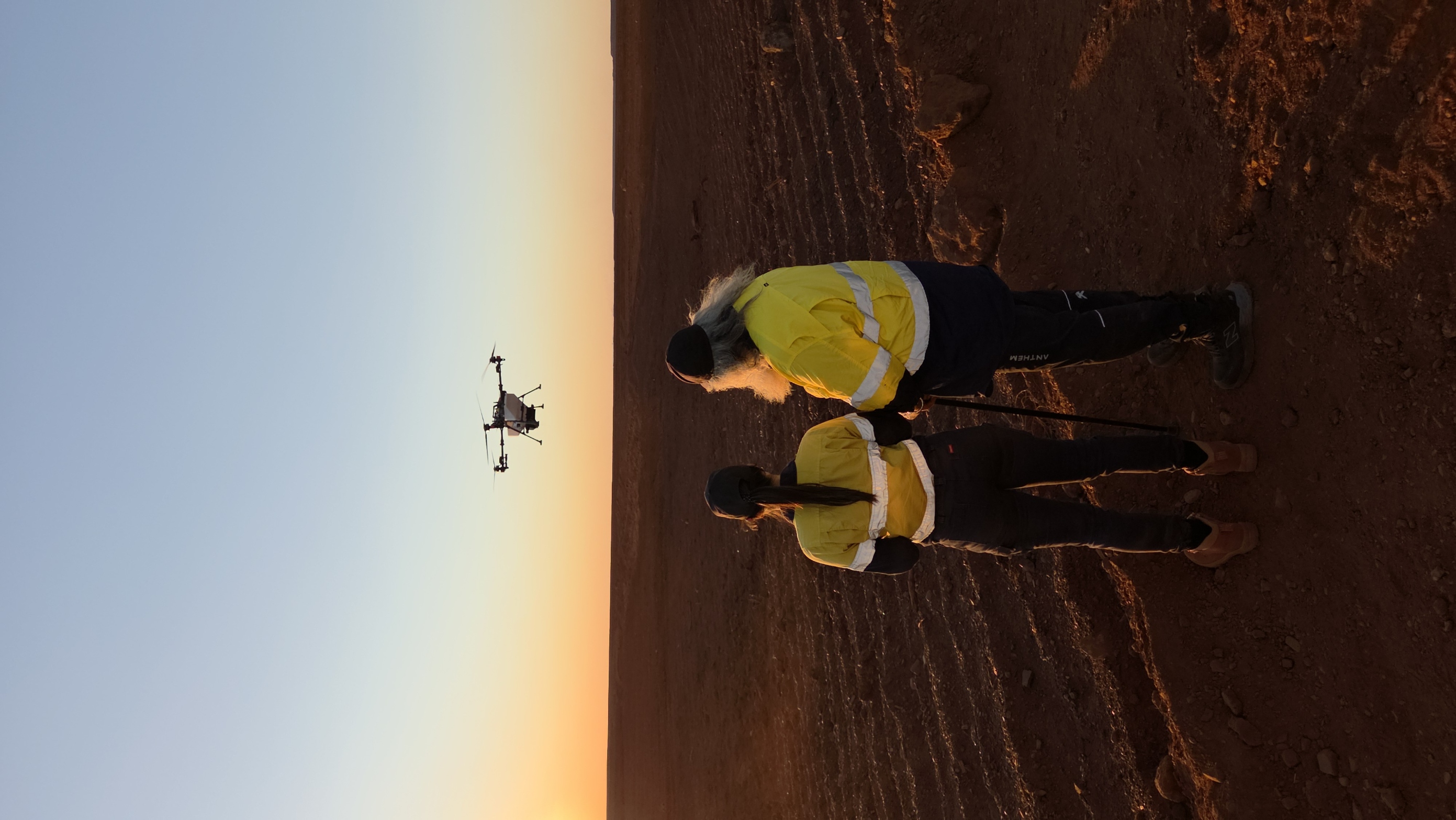 GUMA surveyors flying a drone over a Pilbara site at sunrise