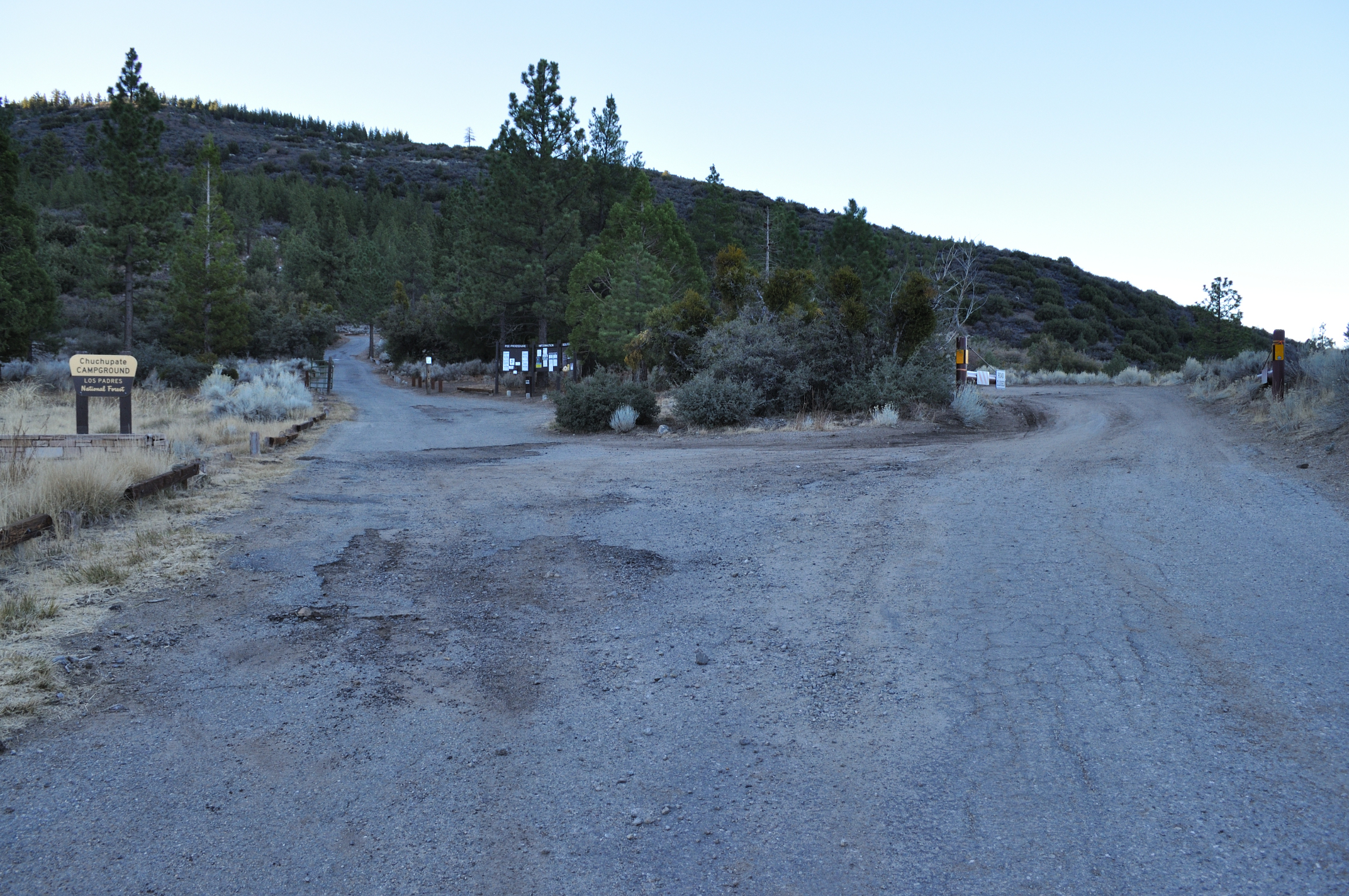 Chuchupate Campground entrance sign, access road, and visitor information boards among pine trees.