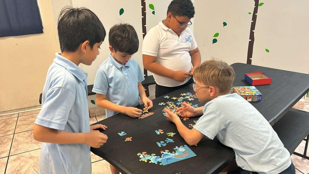 Students building a puzzle together during aftercare