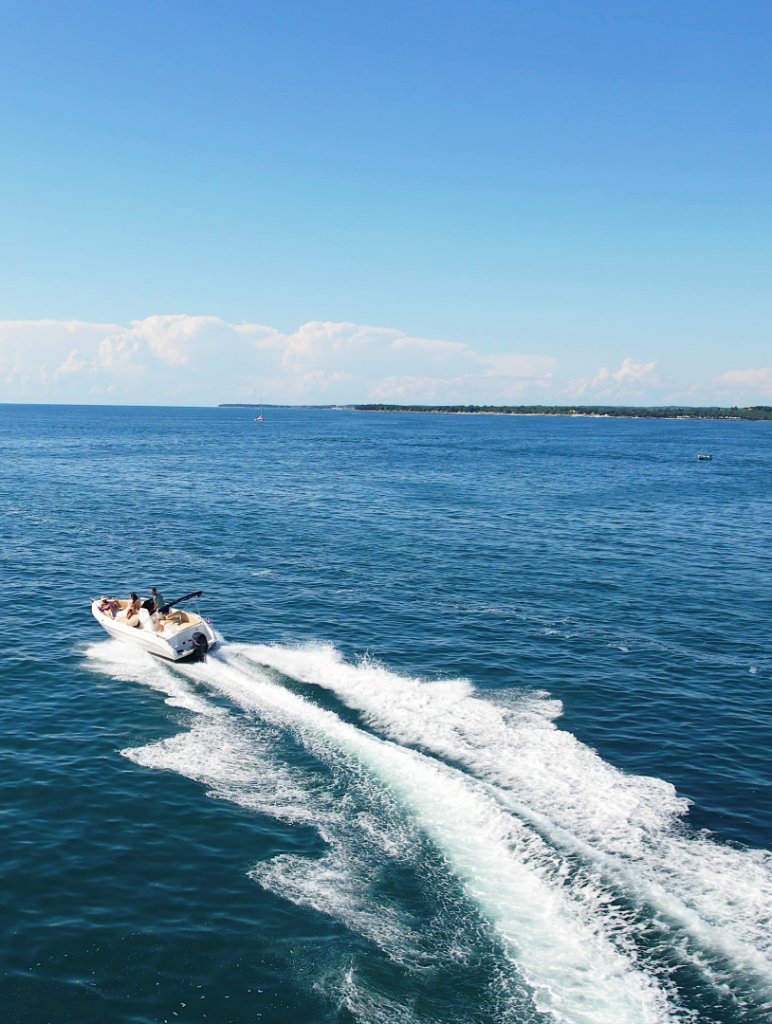 White motorboat cruising across the deep blue Adriatic Sea near Poreč, Istria