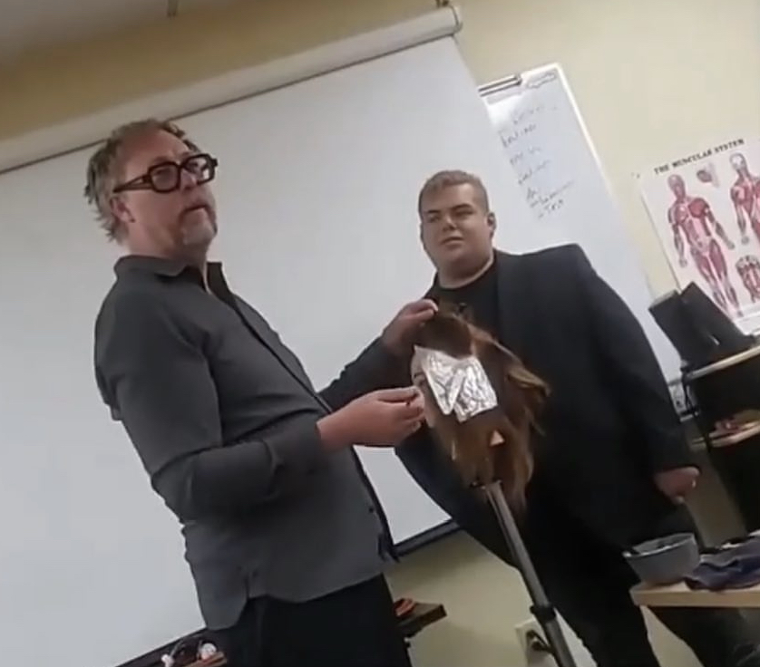 Two educators demonstrating a technique on a mannequin head during a hands-on class