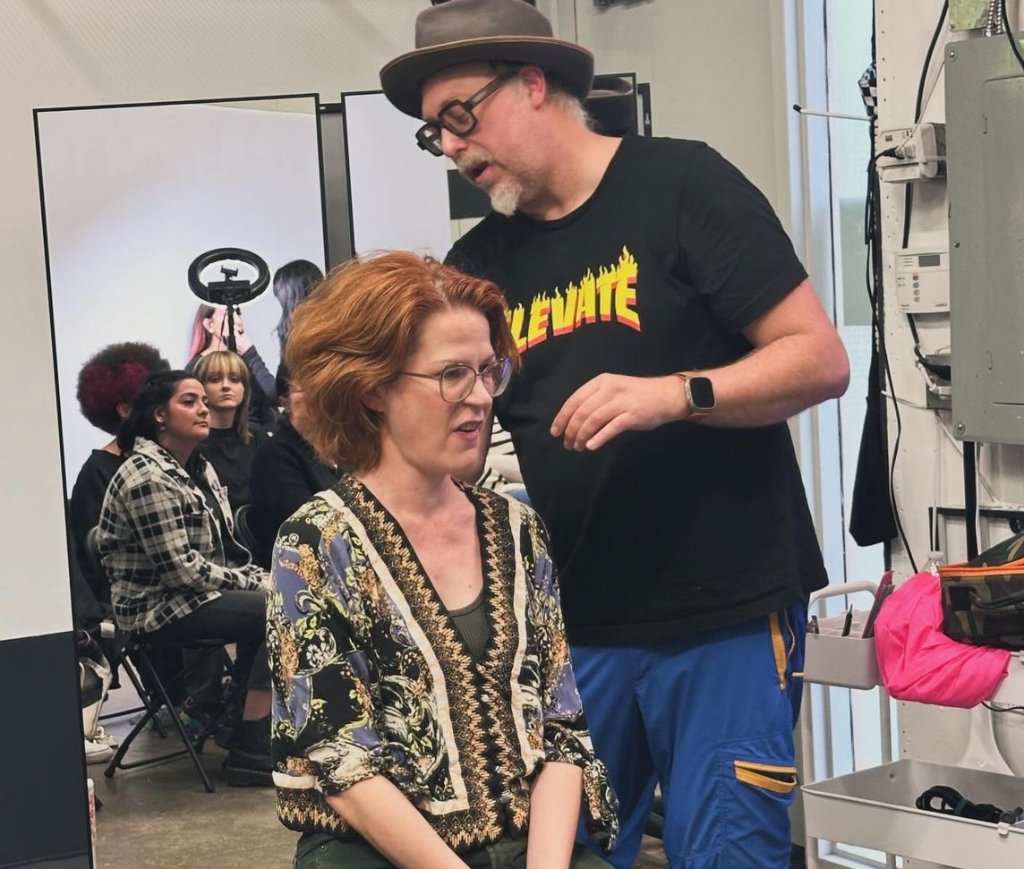 Educator mentoring a stylist during a one-on-one coaching session in the salon