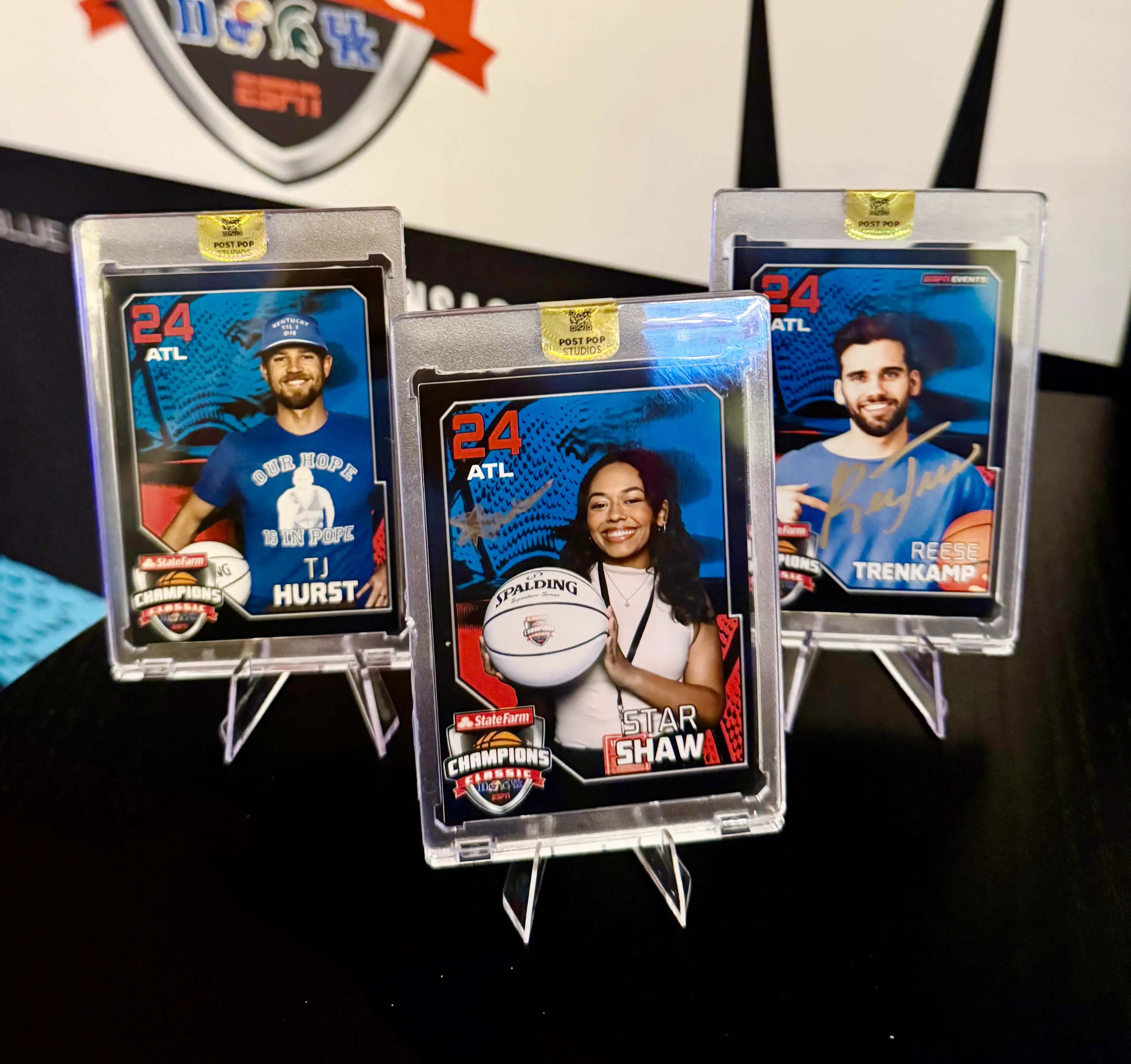 Three custom trading cards displayed on clear acrylic stands
