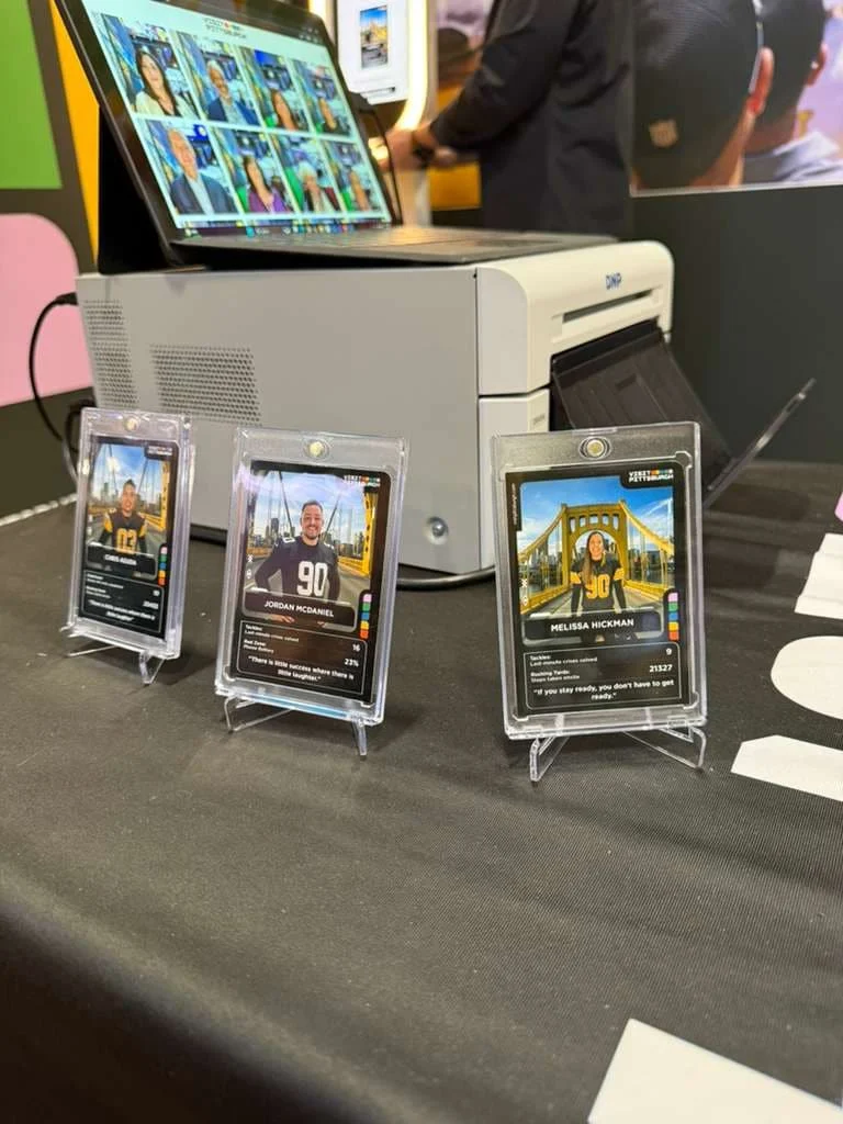 Photo booth setup with a professional printer producing trading cards on site