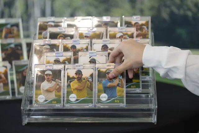 A multi-tiered acrylic display stand filled with finished trading cards