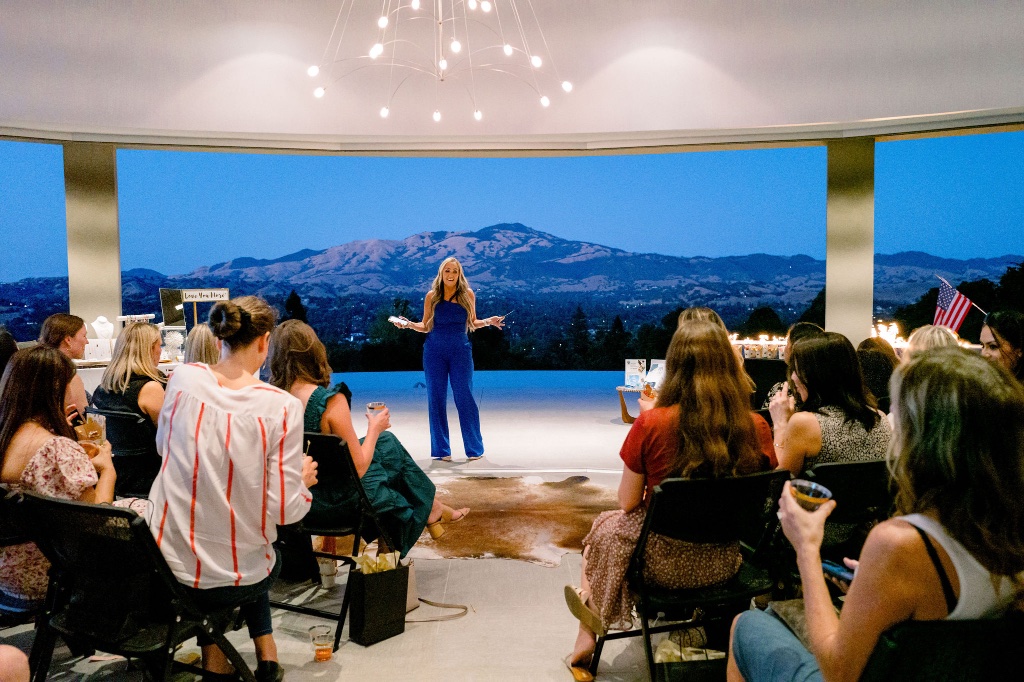 A woman speaking to the community at a She Connects event