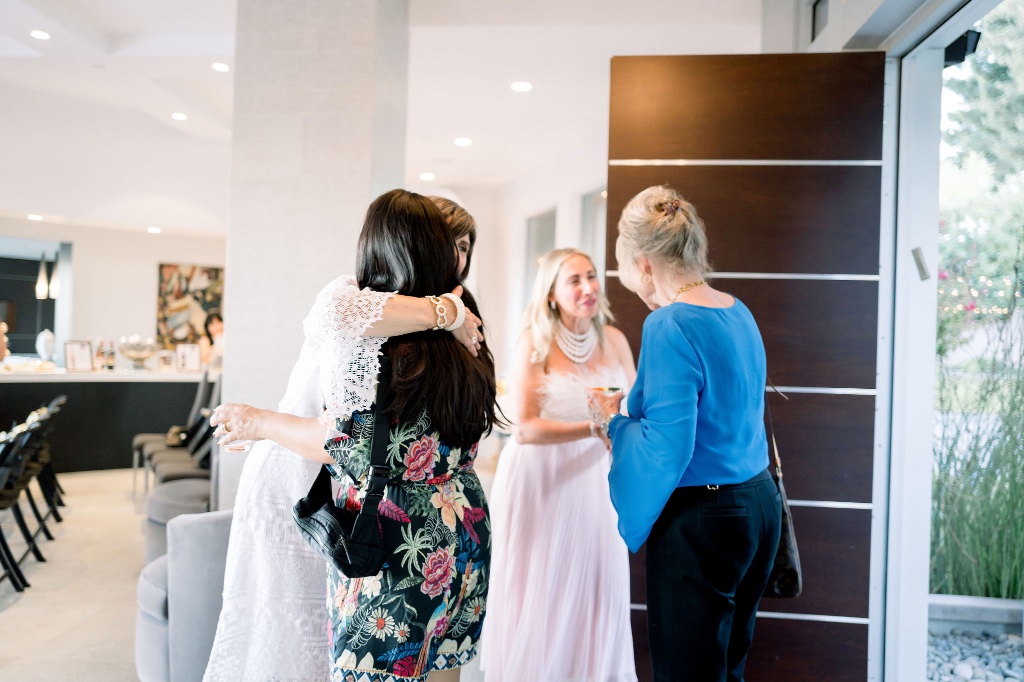 Two women sharing a warm hug at a gathering