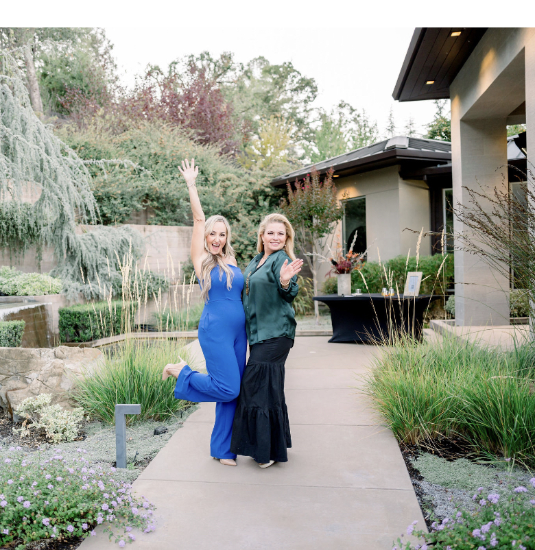Two women waving on a patio at a community gathering
