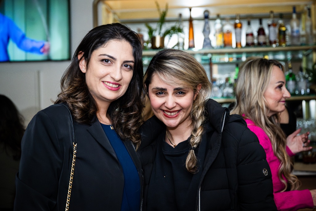 Two friends posing together at an evening event
