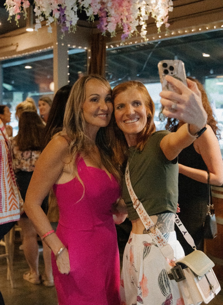 Two friends capturing a selfie at a She Connects event