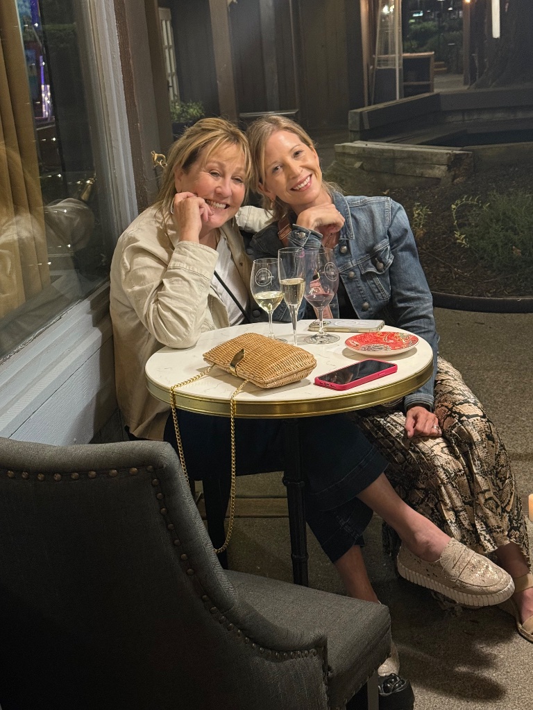 Two women sharing a moment at a table during an evening event