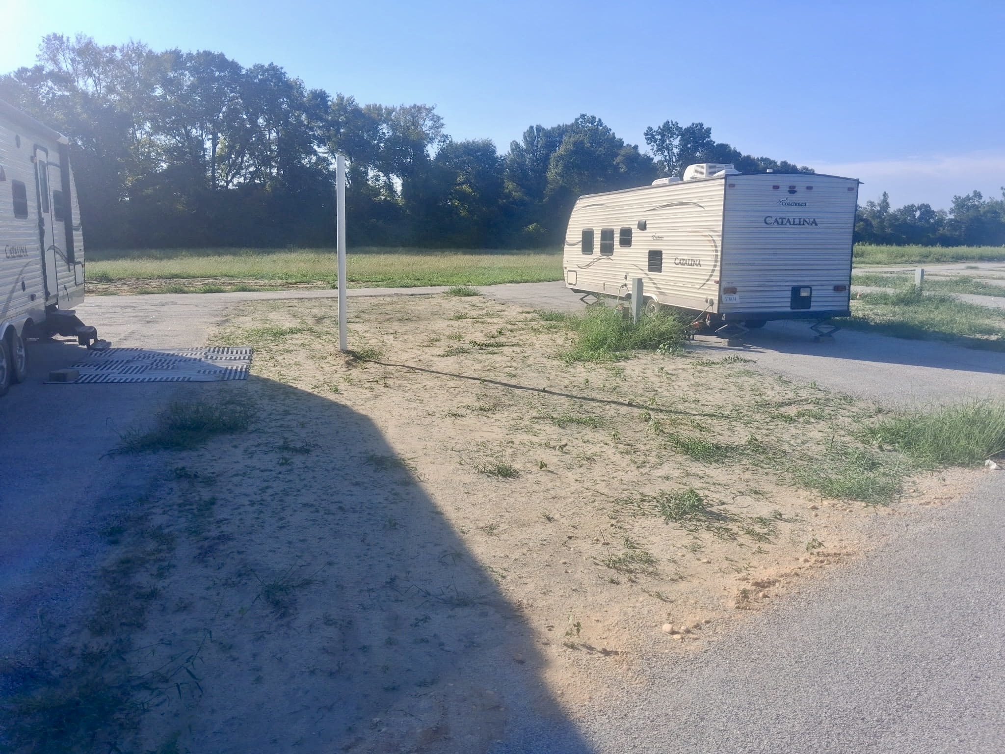 Catalina travel trailer parked on a gravel site with a striped patio mat