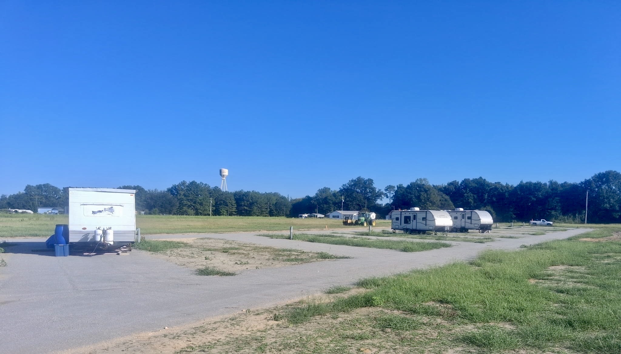 Wide view of RVs parked in a row with a water tower on the horizon