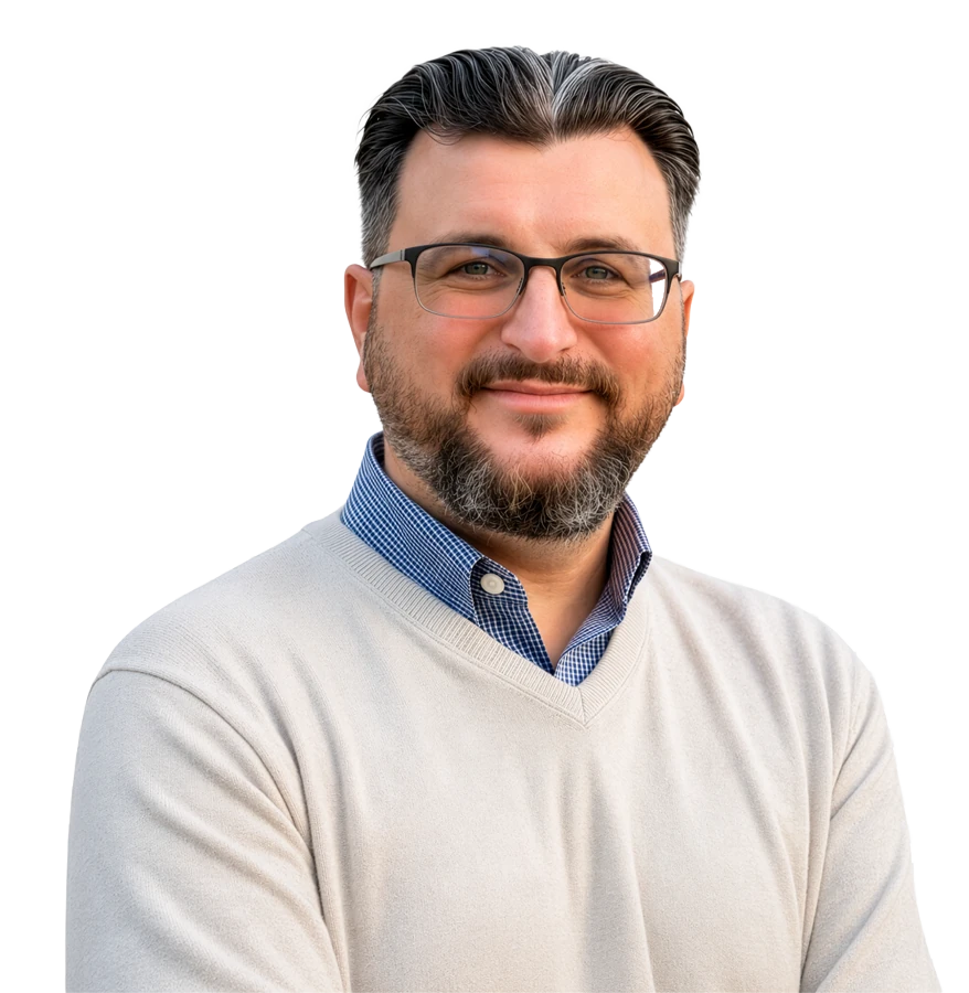Professional author headshot of a smiling bearded man with glasses, wearing a light sweater over a blue collared shirt.