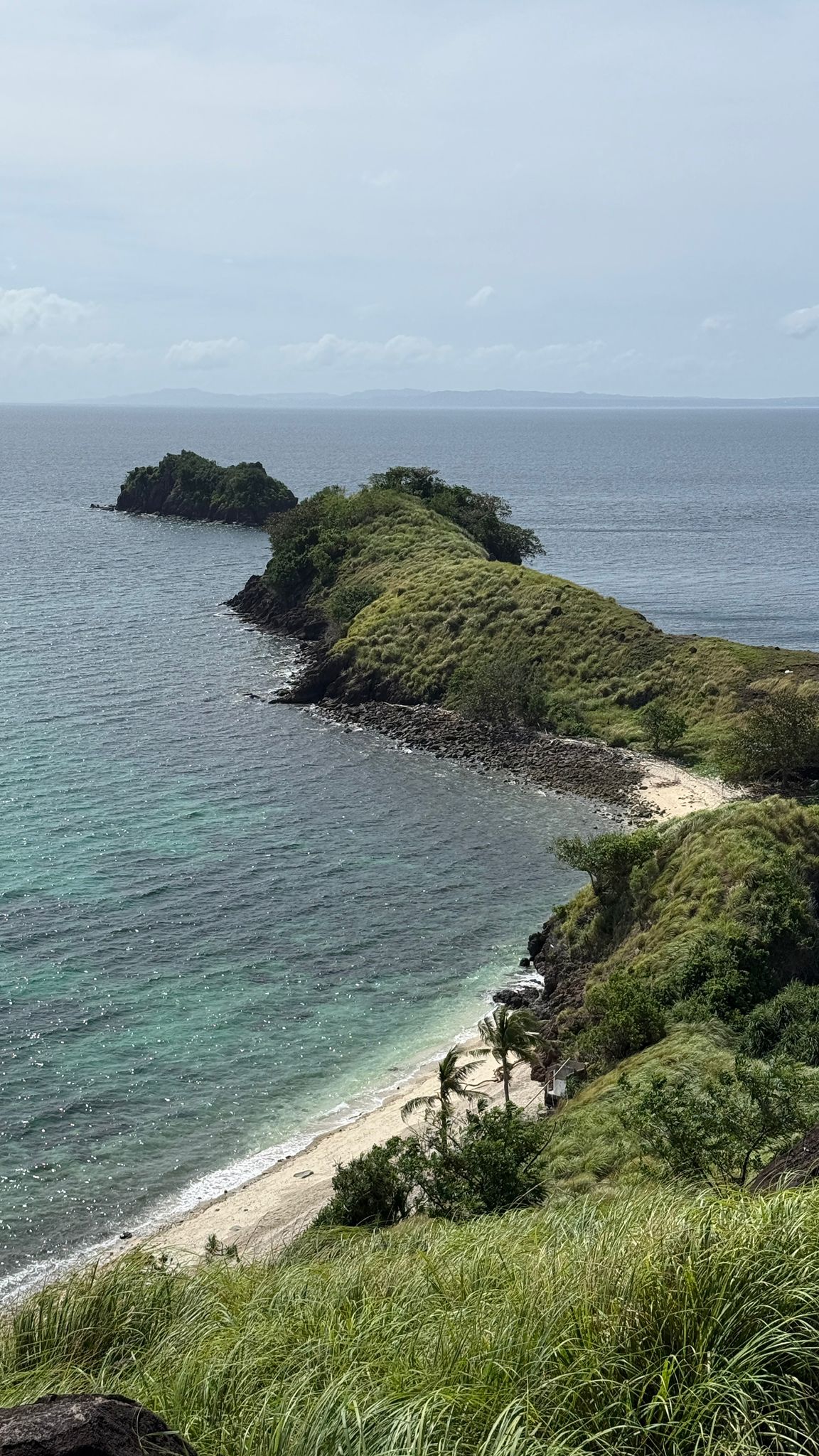 Green peninsula reaching into a deep blue tropical sea