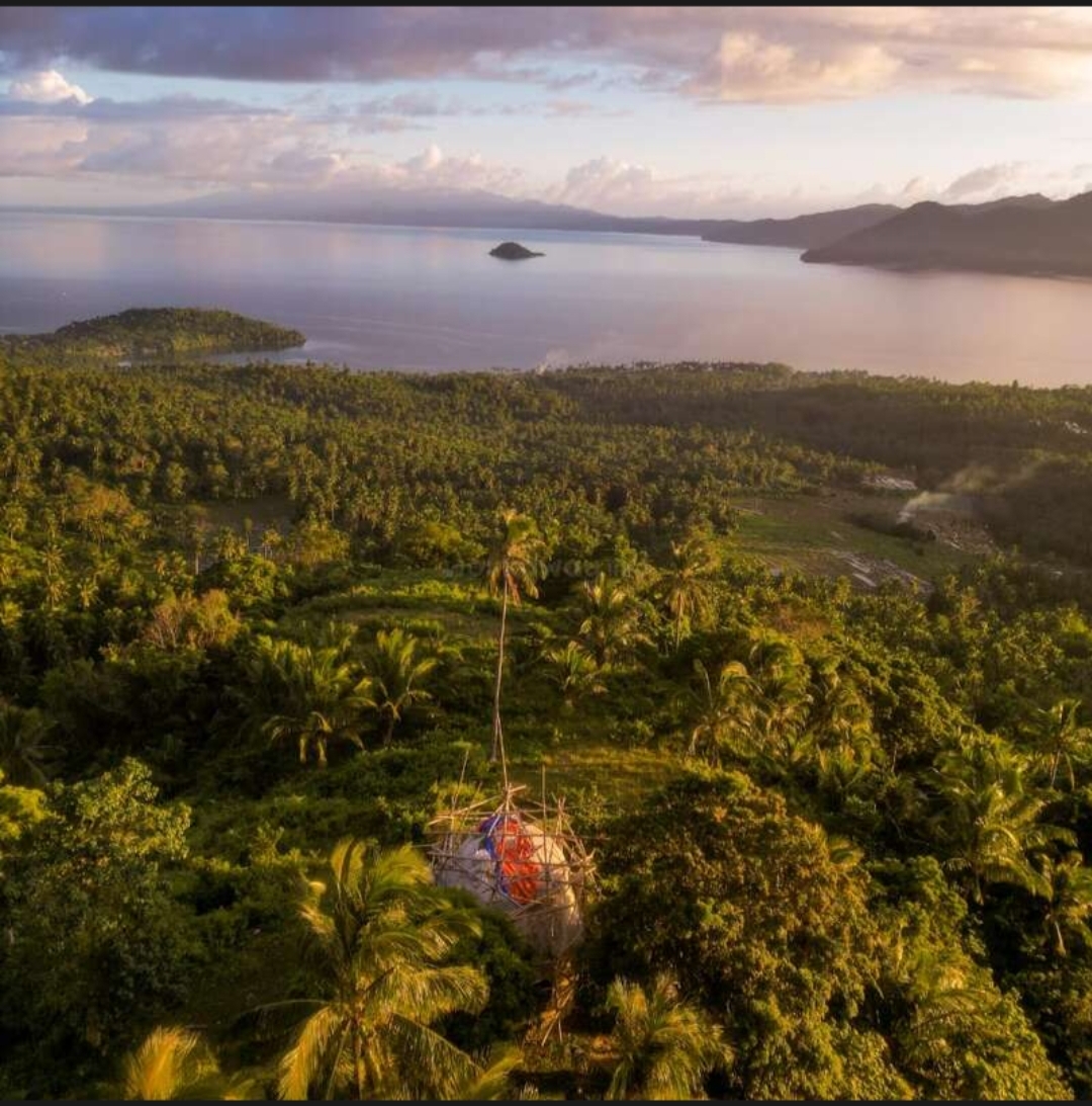 Aerial view at sunset of a bamboo structure under construction above the bay