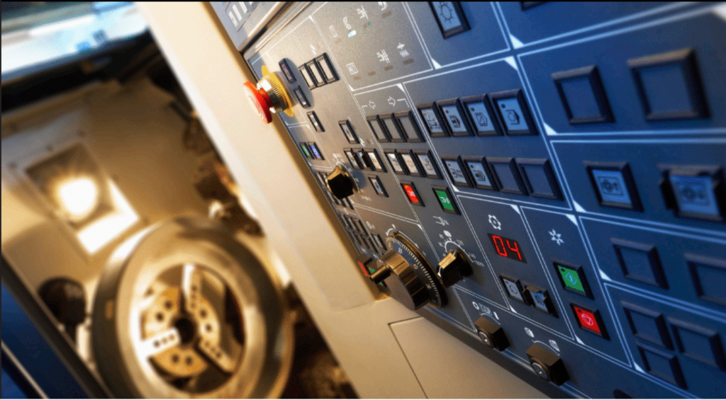 Industrial CNC machine control panel with emergency stop and operator buttons