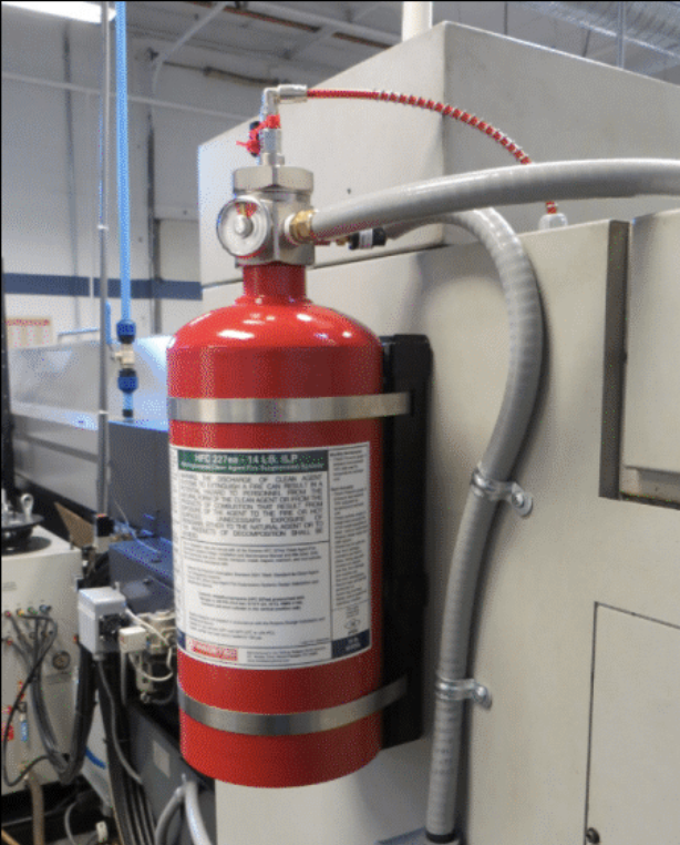 Red FireTek HFC-227ea suppression cylinder mounted to an industrial machine