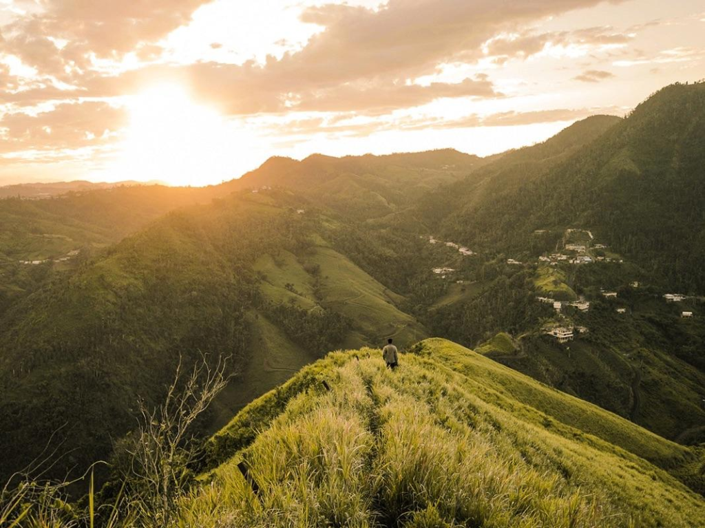 Person overlooking a mountain valley at golden hour sunset
