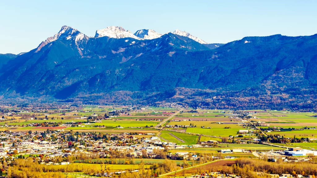 Fraser Valley farmland stretching toward snow-capped mountains