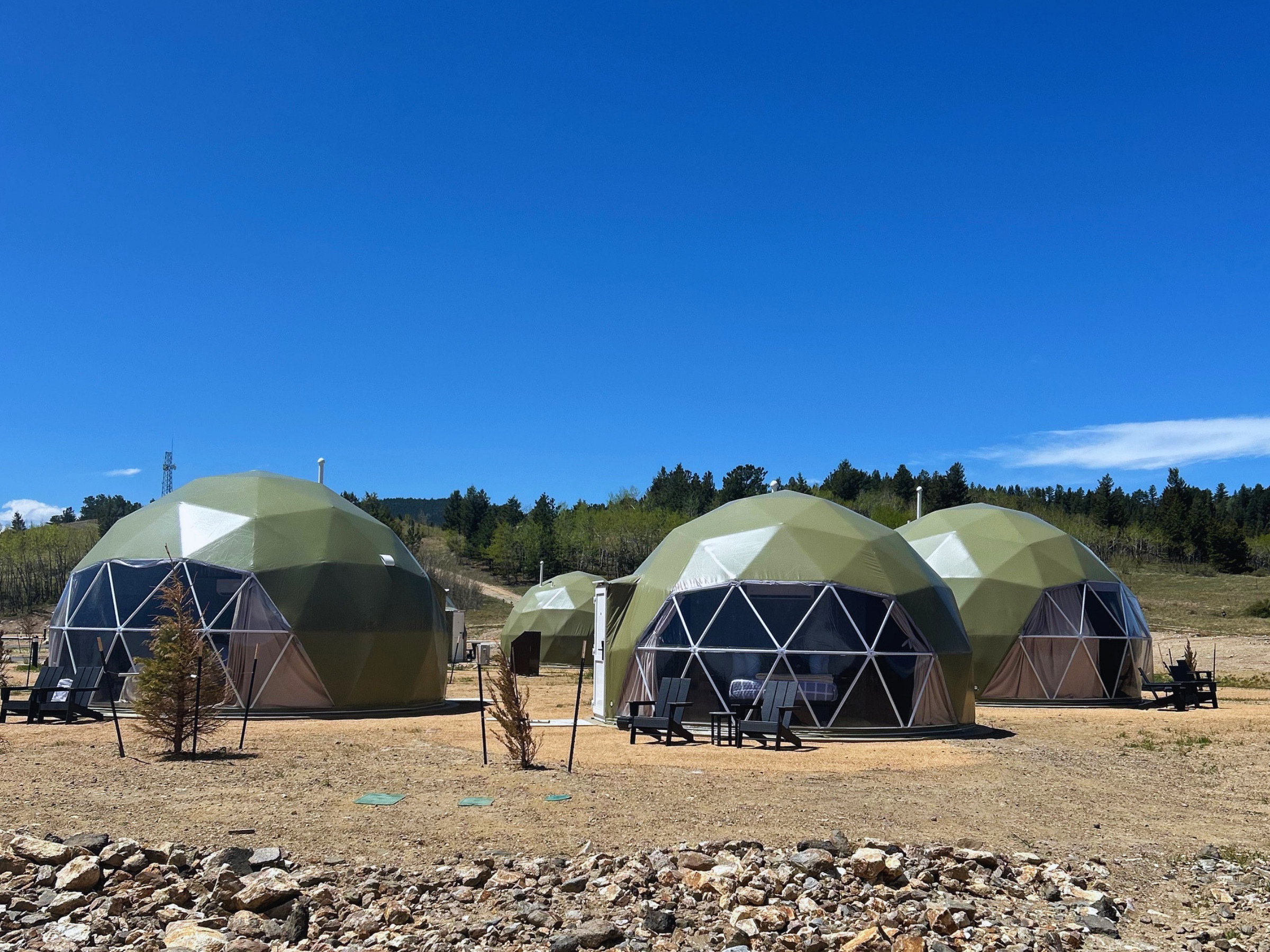 Three geodesic domes under a clear blue sky