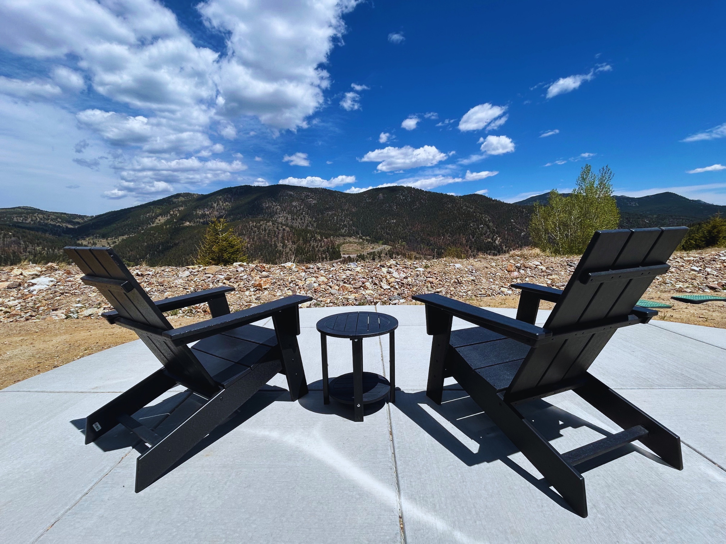 Adirondack chairs on a patio overlooking the mountains