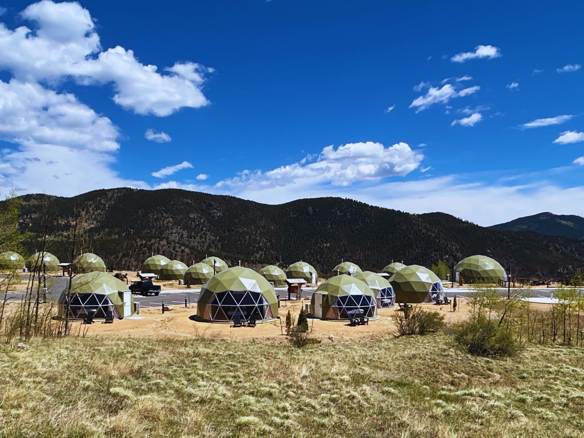 Wide view of The Nest domes and parking against the mountains
