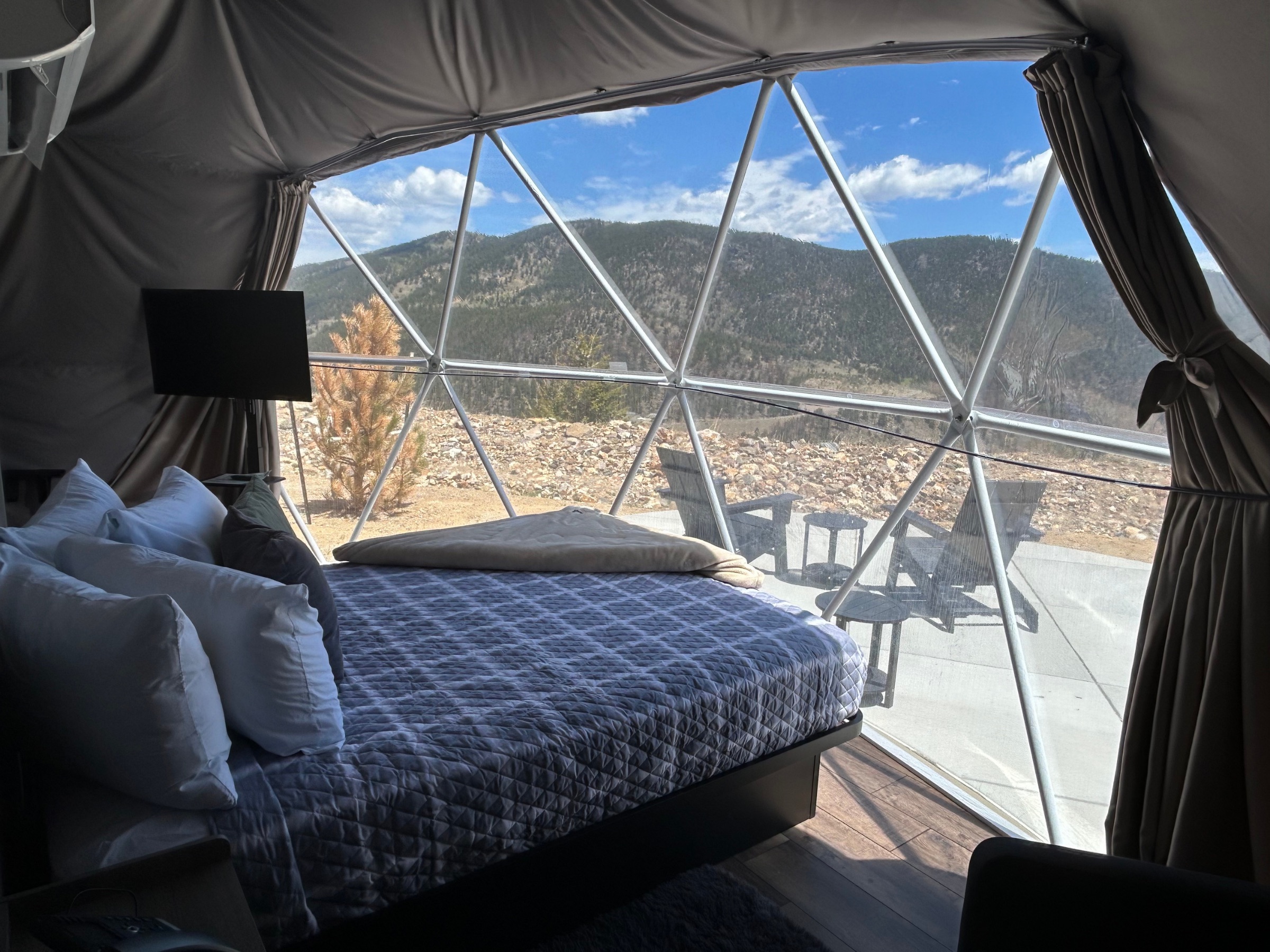 Wide interior view of the Accessible Deluxe Mountain Views Dome with bed and dome frame
