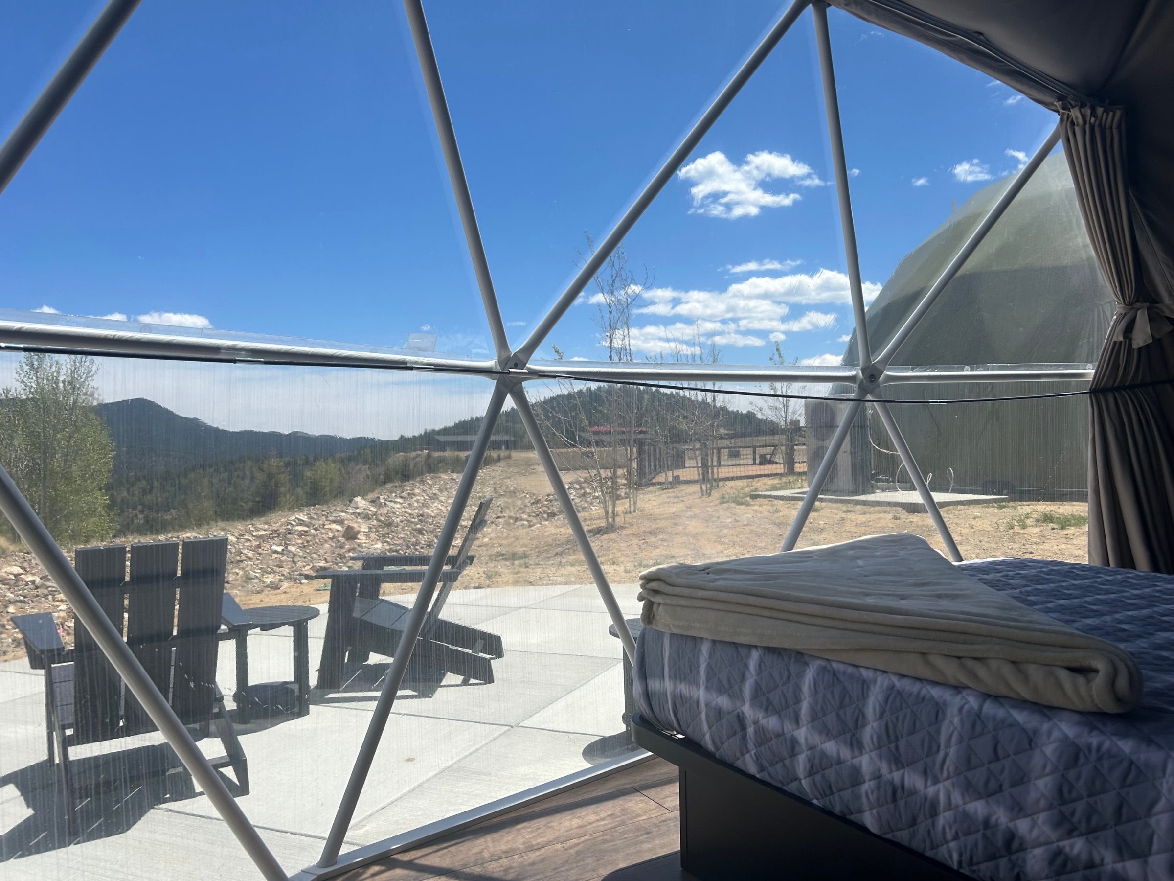 Bed and mountain view through the dome window