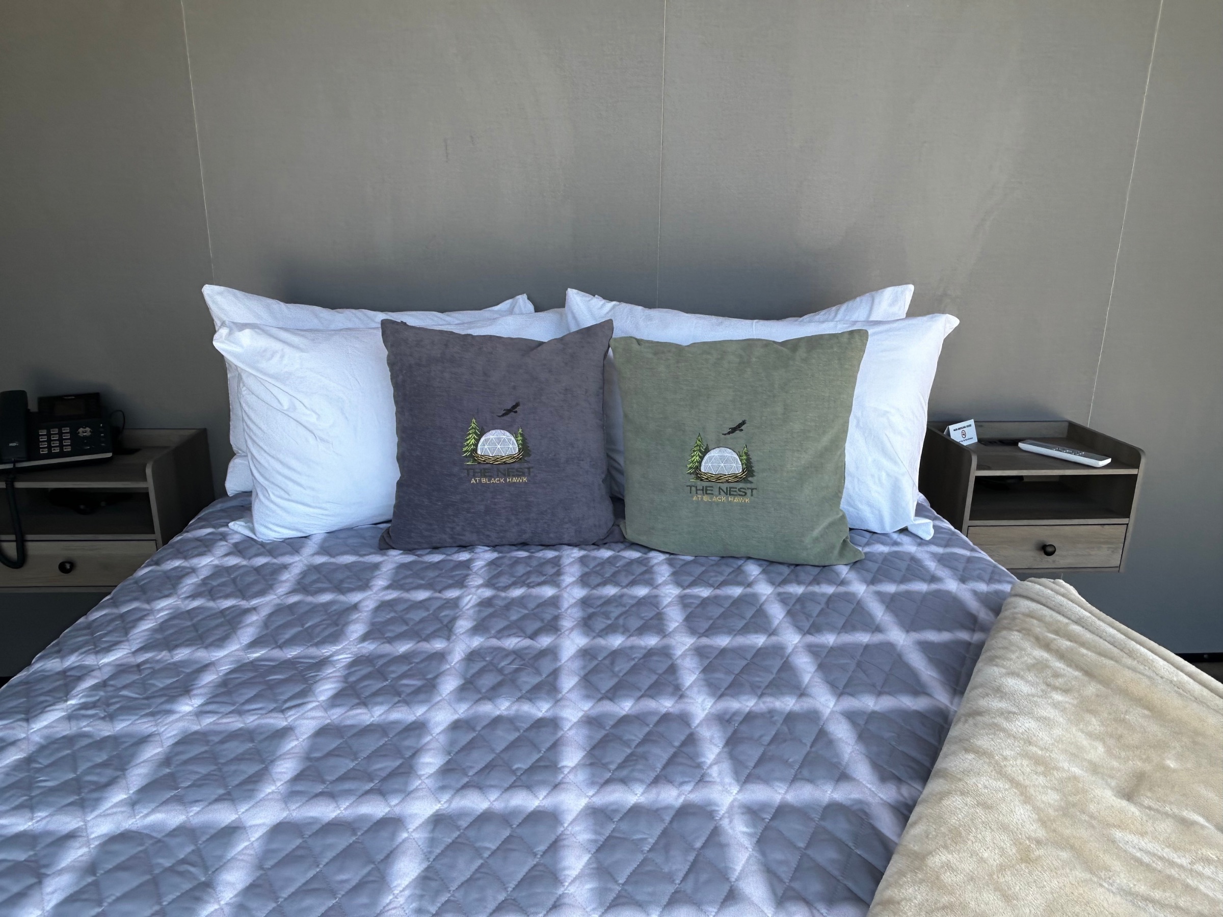 Queen bed with branded The Nest pillows in the Accessible Deluxe Mountain Views Dome