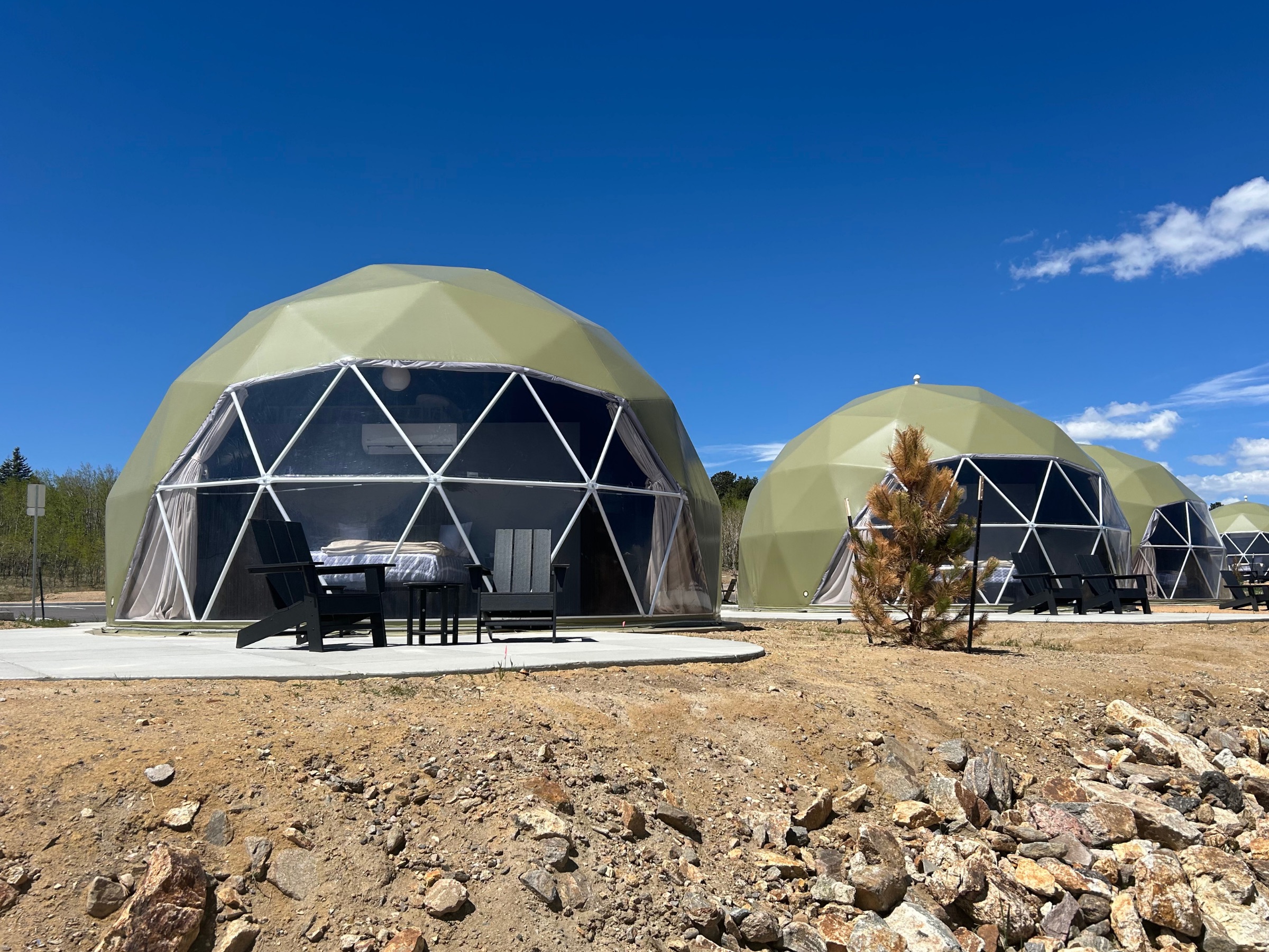 Two geodesic domes with Adirondack chairs on the patio
