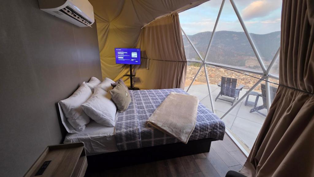Bed and mountain view inside a dome at dusk