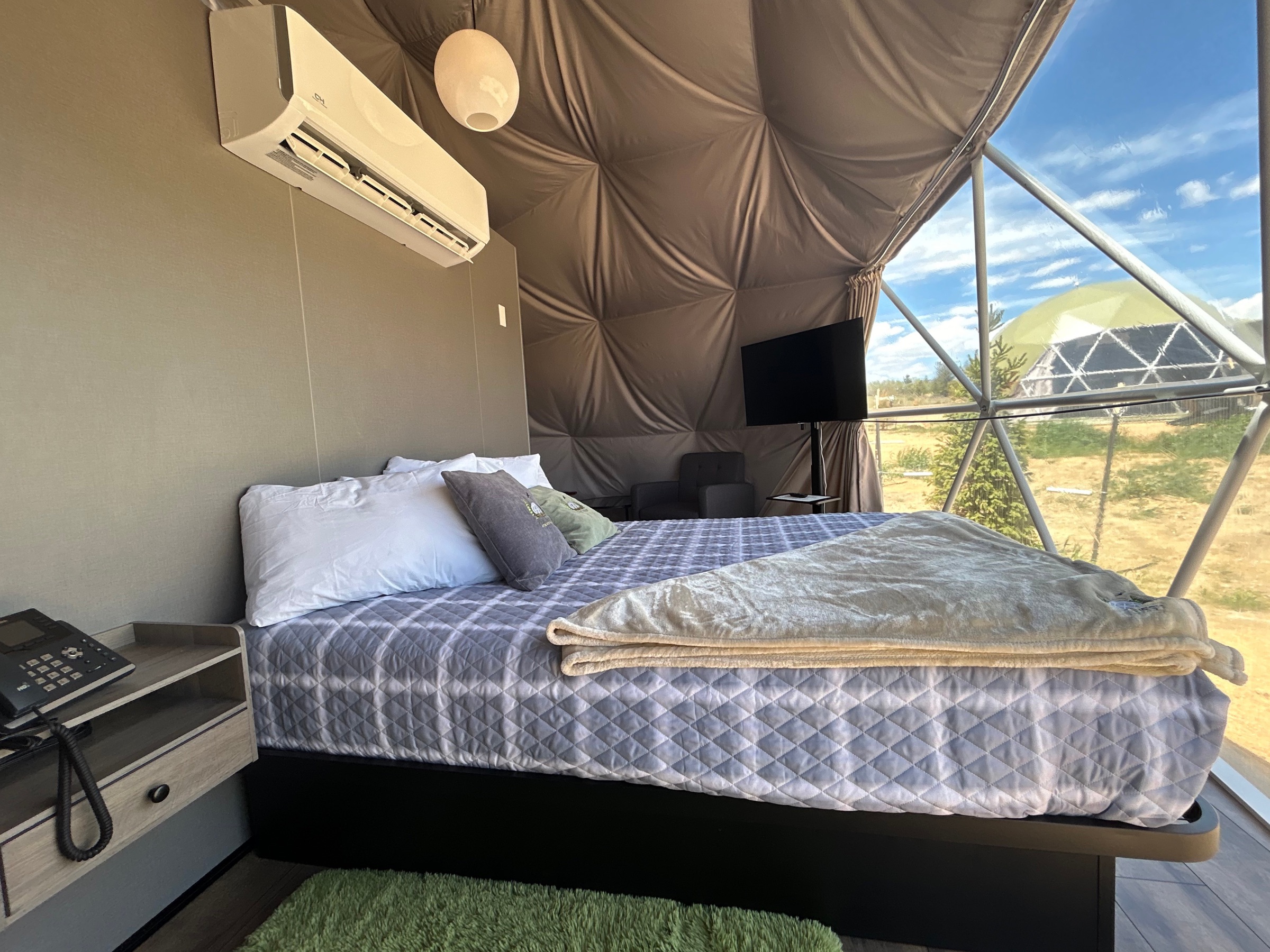 Wide interior view of the Mountain Views Dome with bed and dome frame