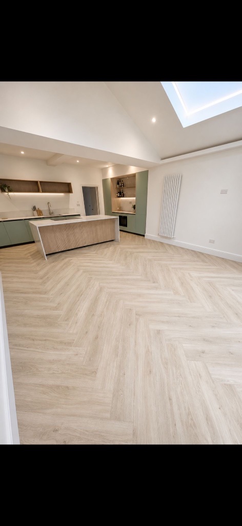 Light oak herringbone LVT flooring in a bright modern kitchen and living space