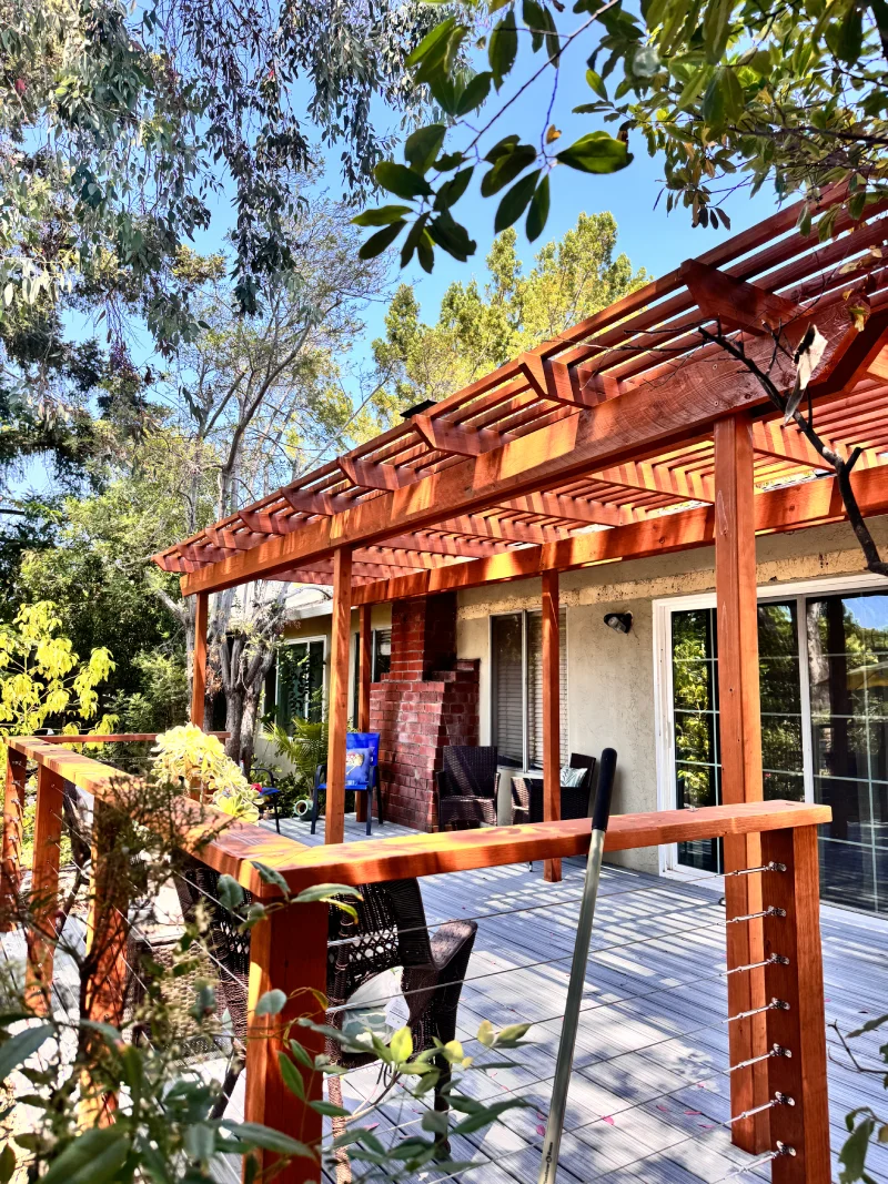 Redwood pergola over a backyard deck