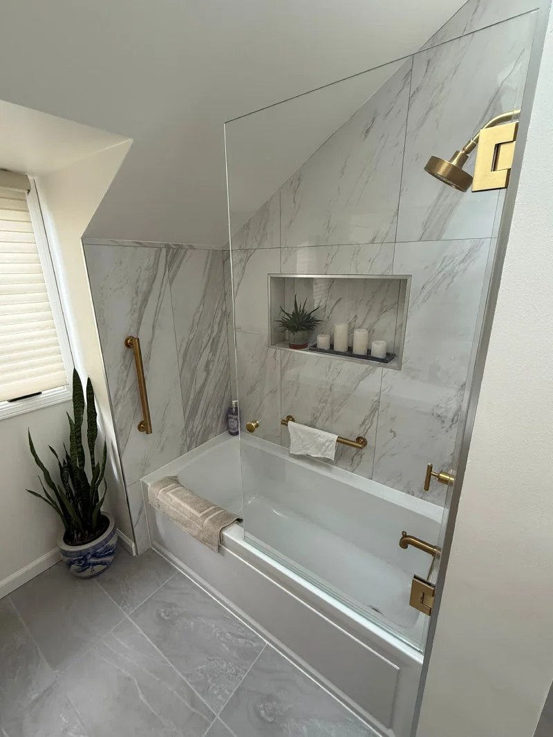 Marble tub and shower surround with brass trim