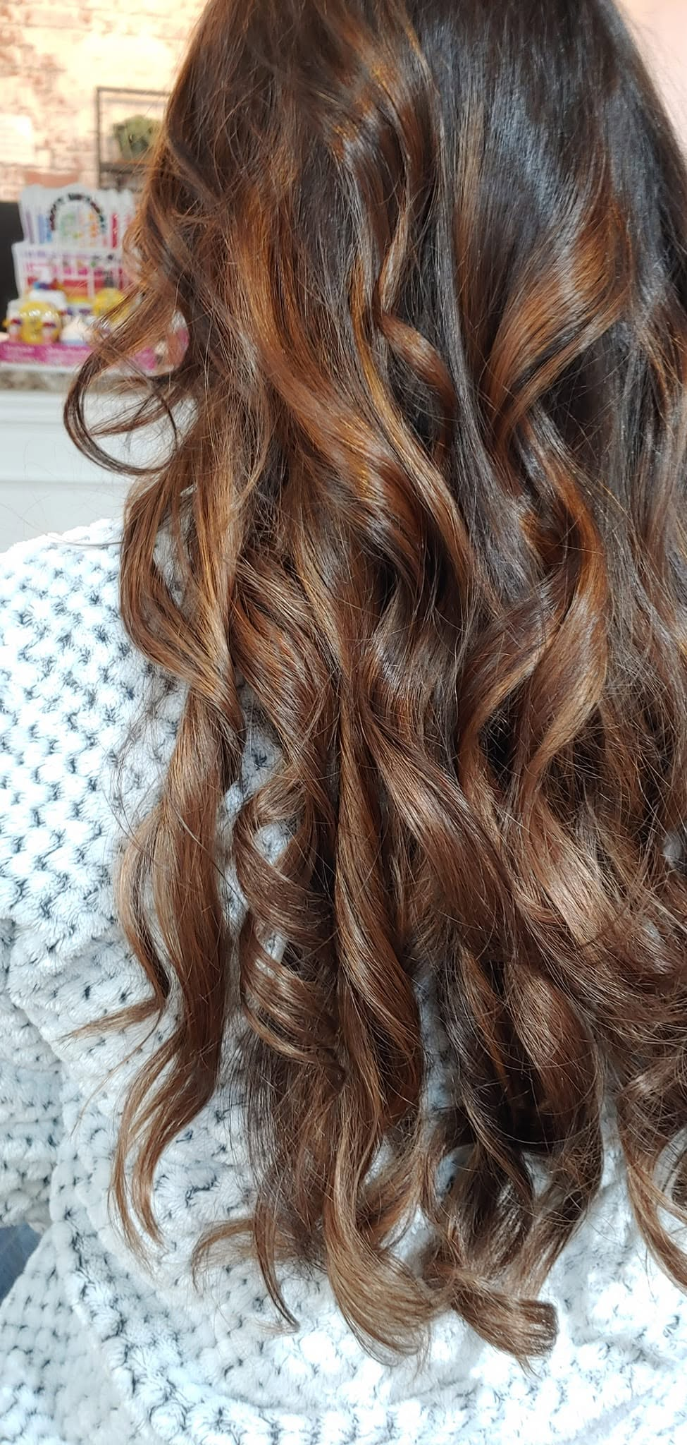 Dark brown hair with warm copper balayage in soft waves