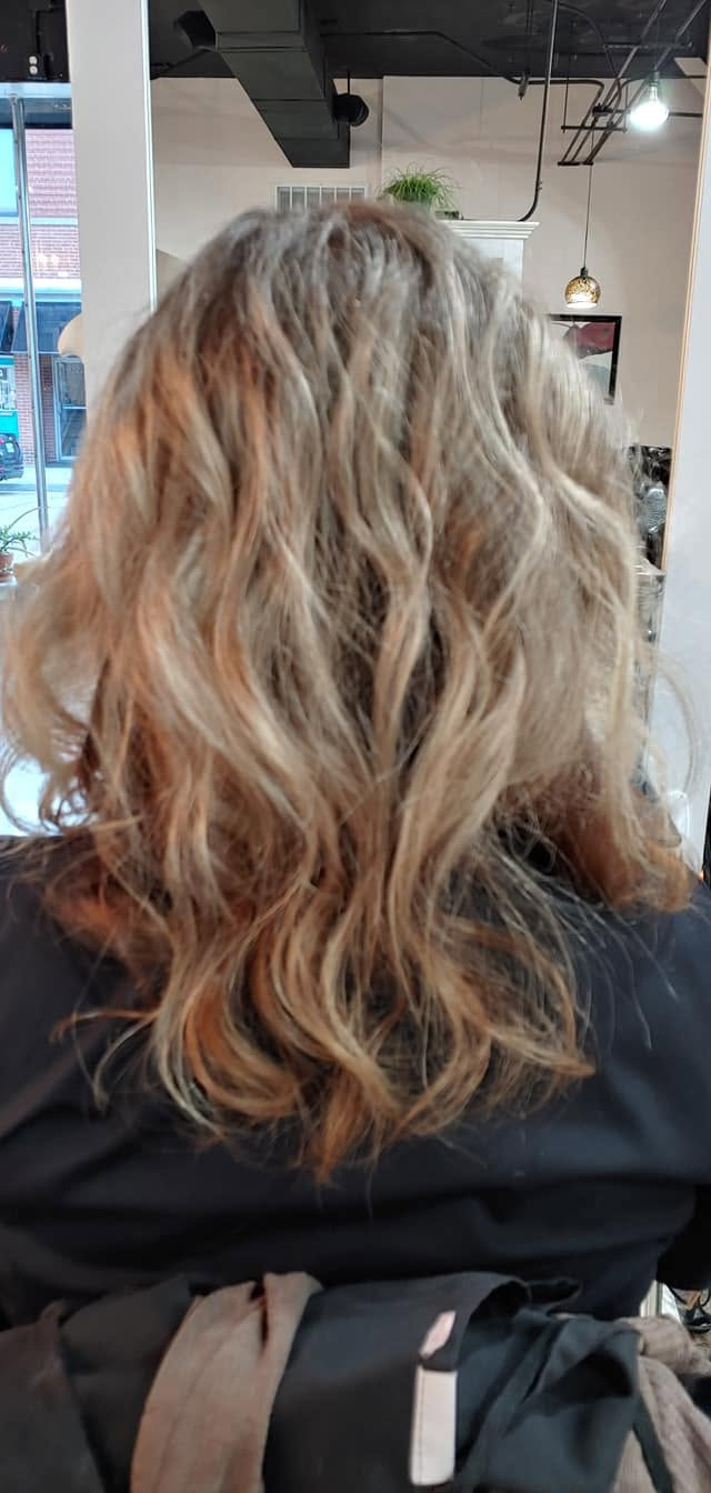 Multi-tonal blonde and copper wavy hair styled in the salon