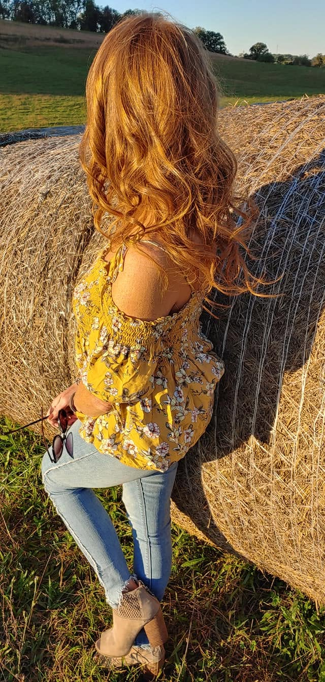Voluminous reddish-brown wavy hair in golden hour light