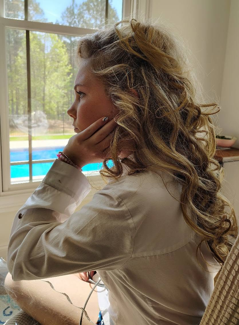Profile of textured blonde curls lit by a window