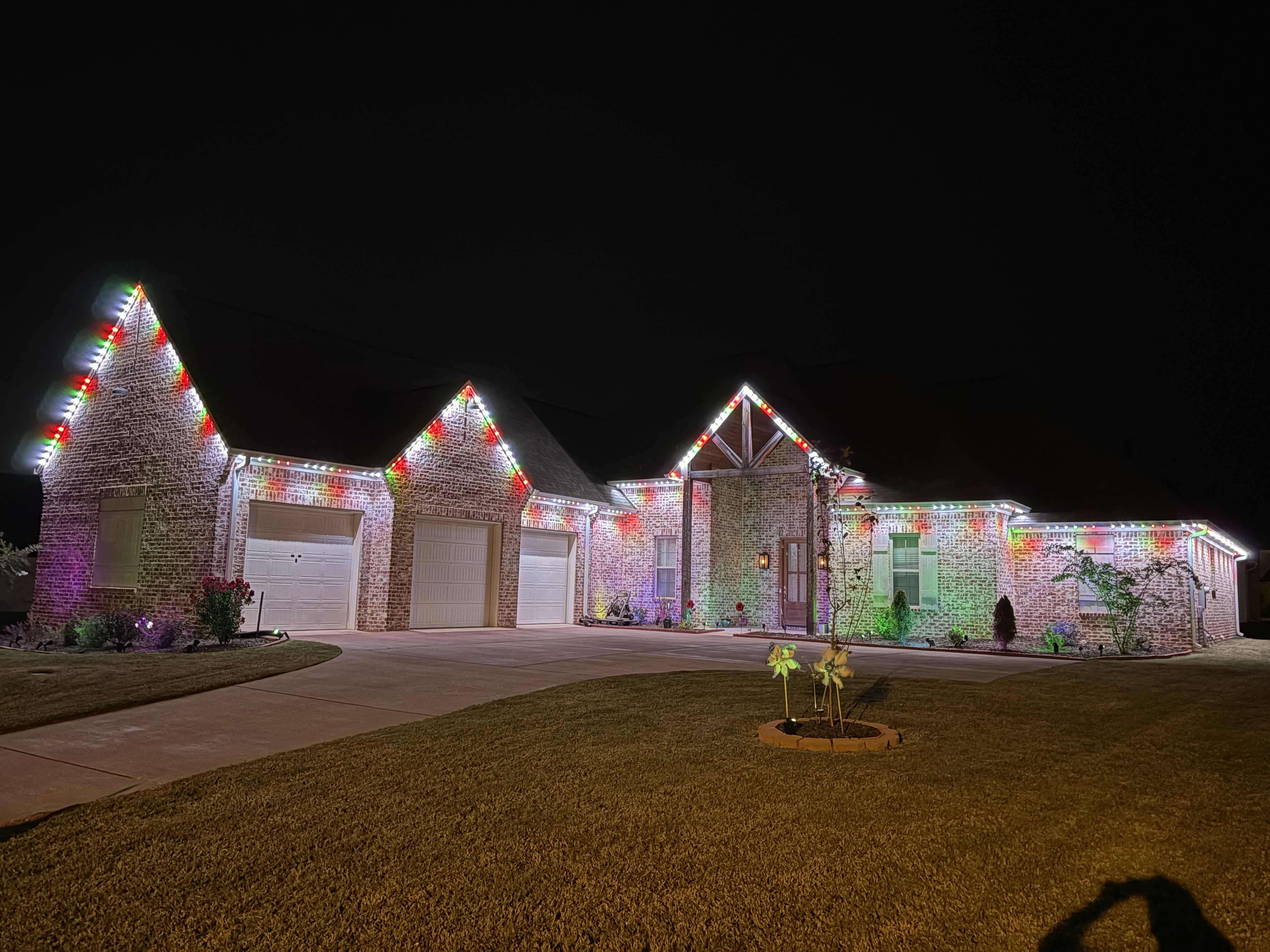 Brick home with red green and white holiday LED lighting