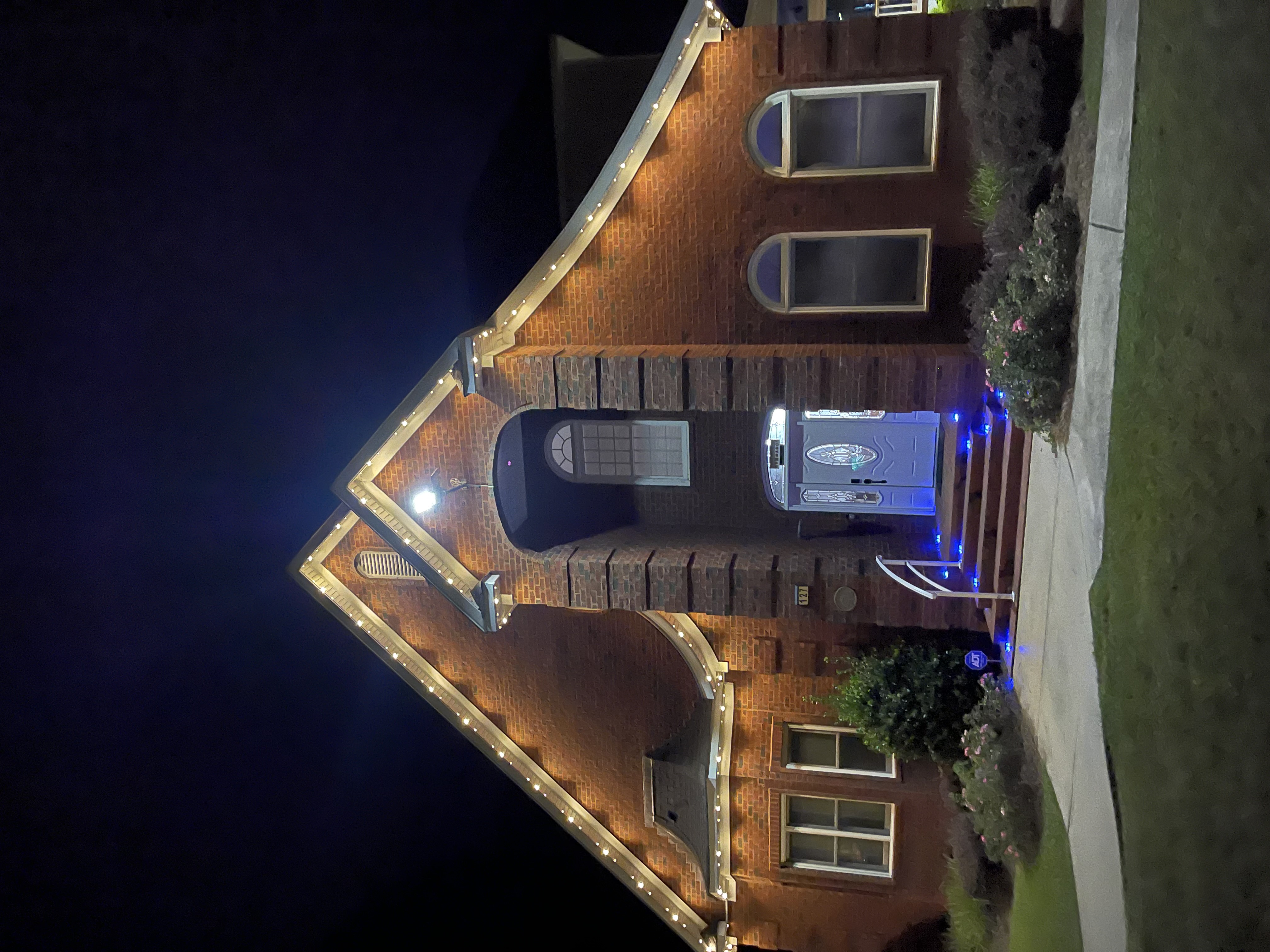 Brick home with white roofline and blue accent LED lighting