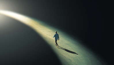Silhouette walking along a beam of light