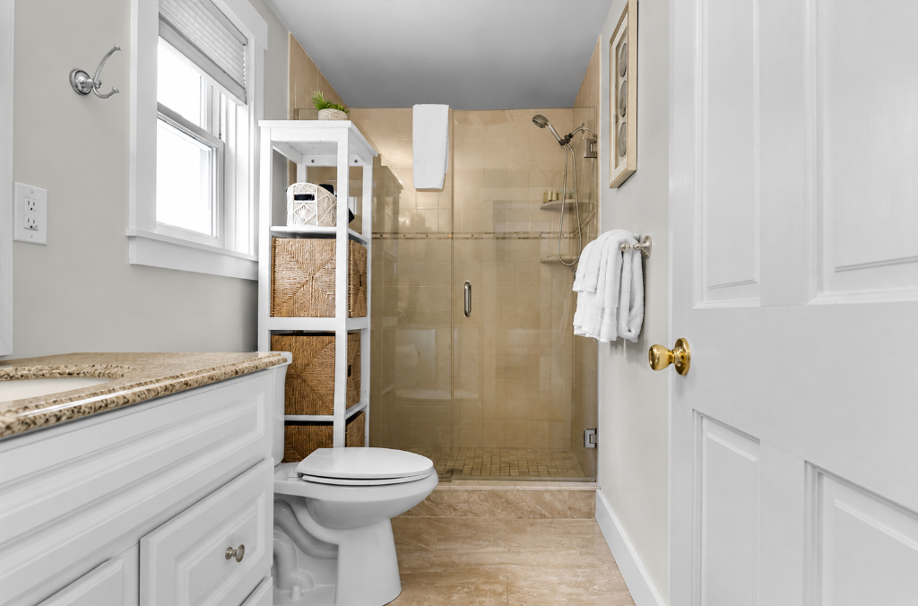Bathroom with glass shower and white vanity at Summer Wind