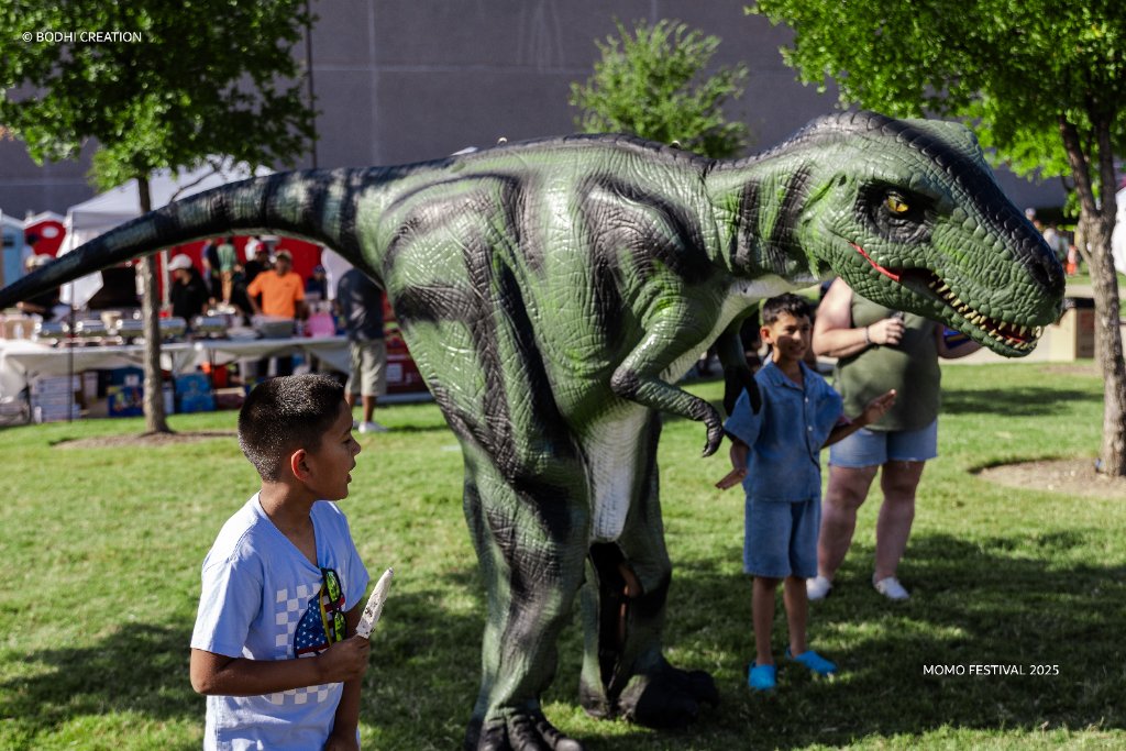 Dinosaur costume delighting kids at the festival