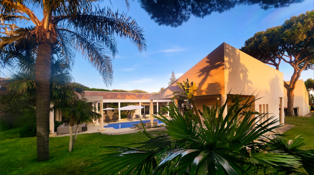 Villa mit Pool und Palme zur goldenen Stunde