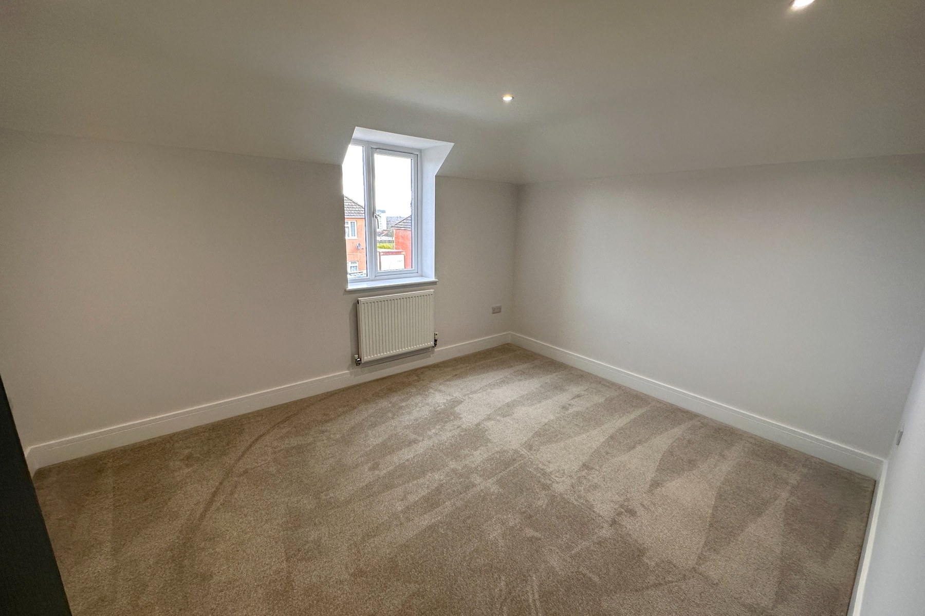 Bedroom with neutral carpet and white trim.